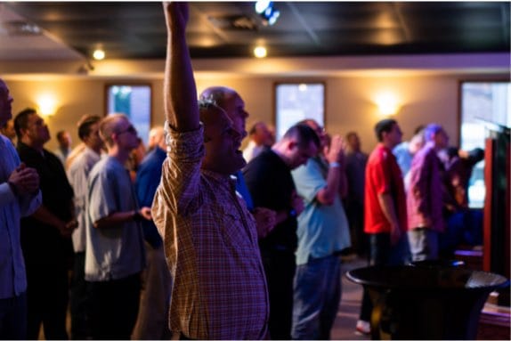 men during a church service praising